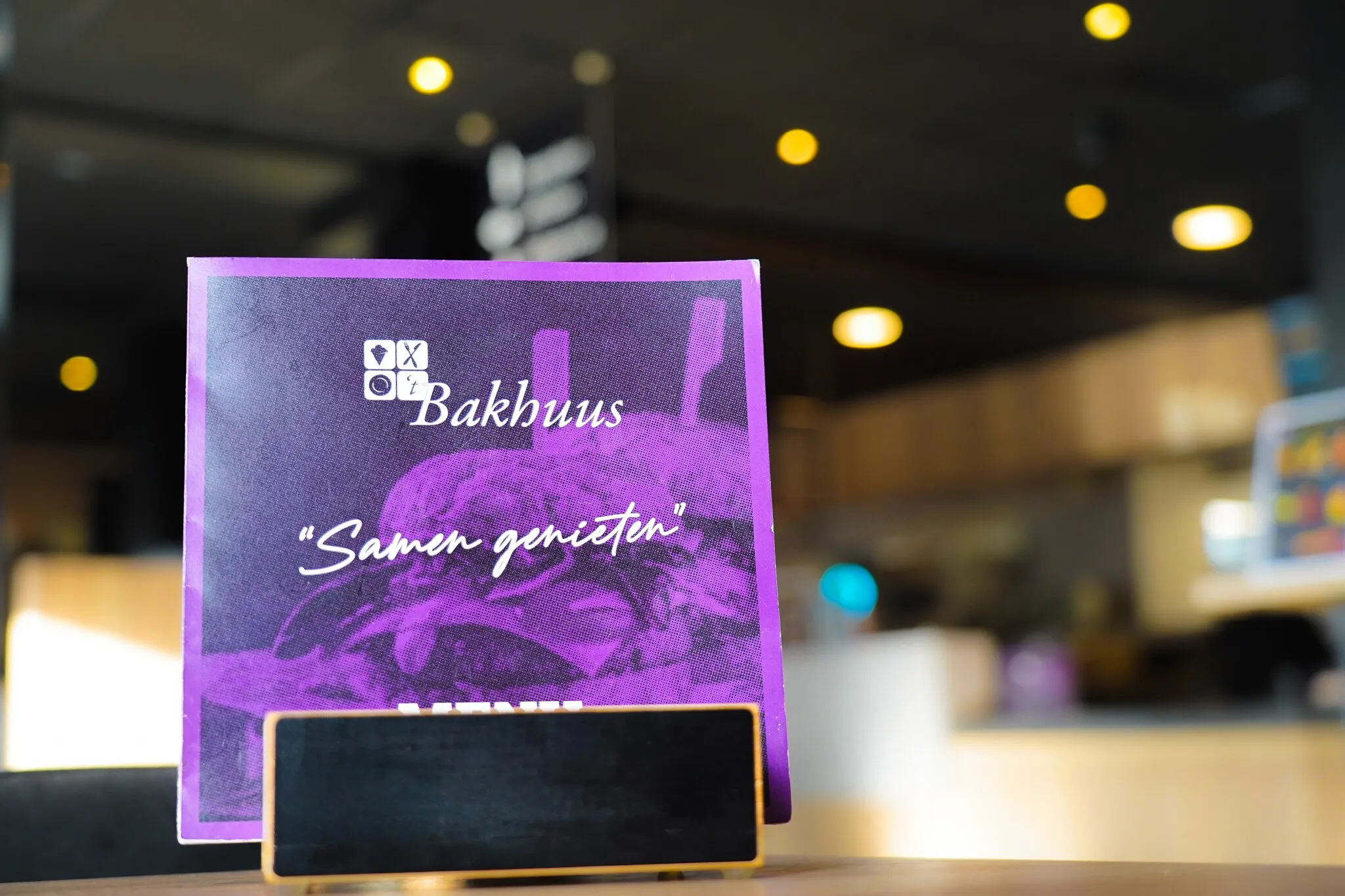 Bordje met de tekst Samen genieten op een tafel bij Bakhuus