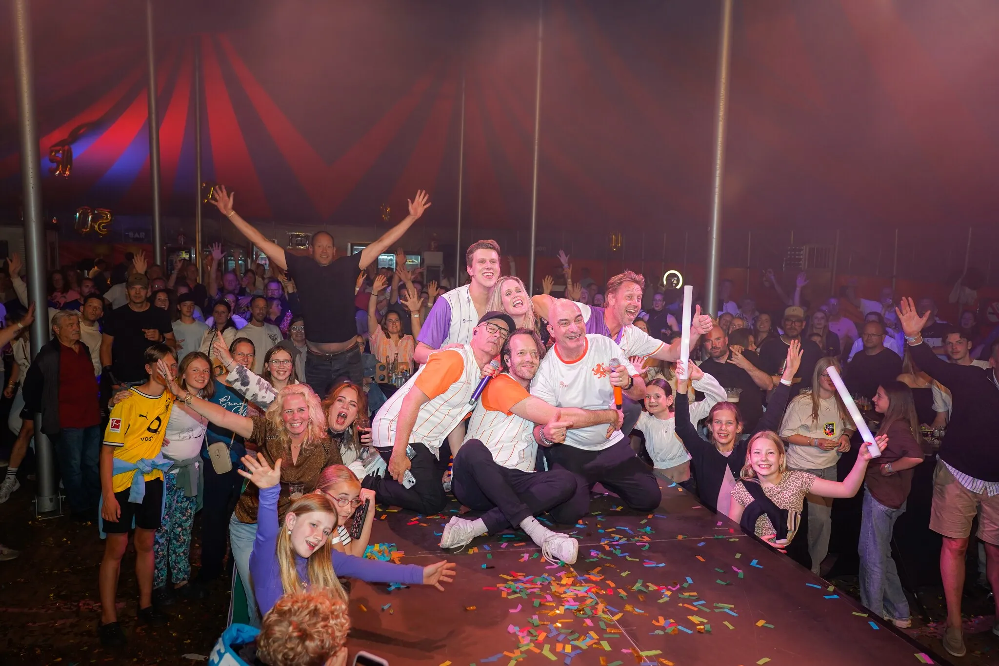 Groepsfoto tijdens een feest met confetti in de lucht