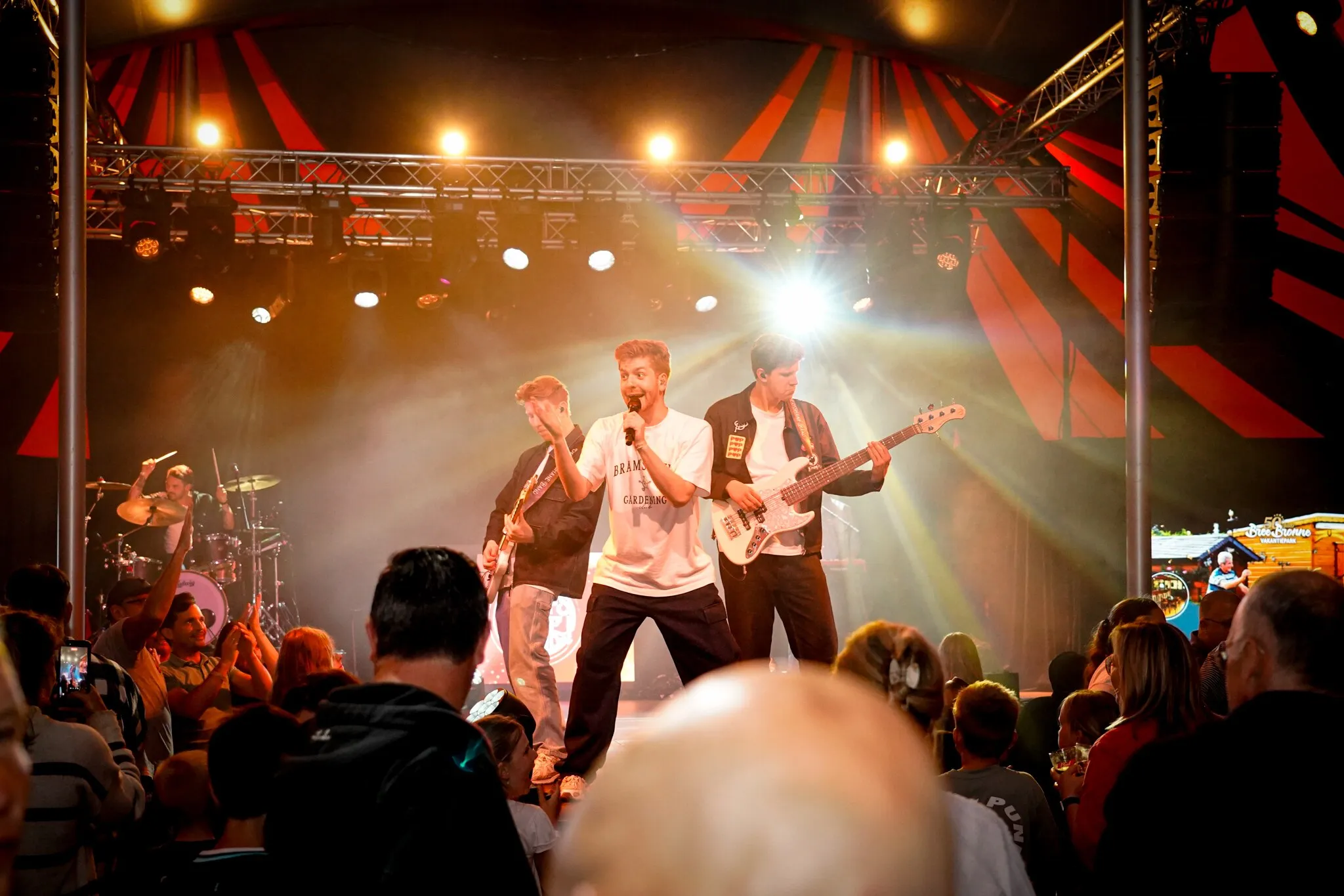 Band op het podium tijdens een festival, gezien vanuit het publiek