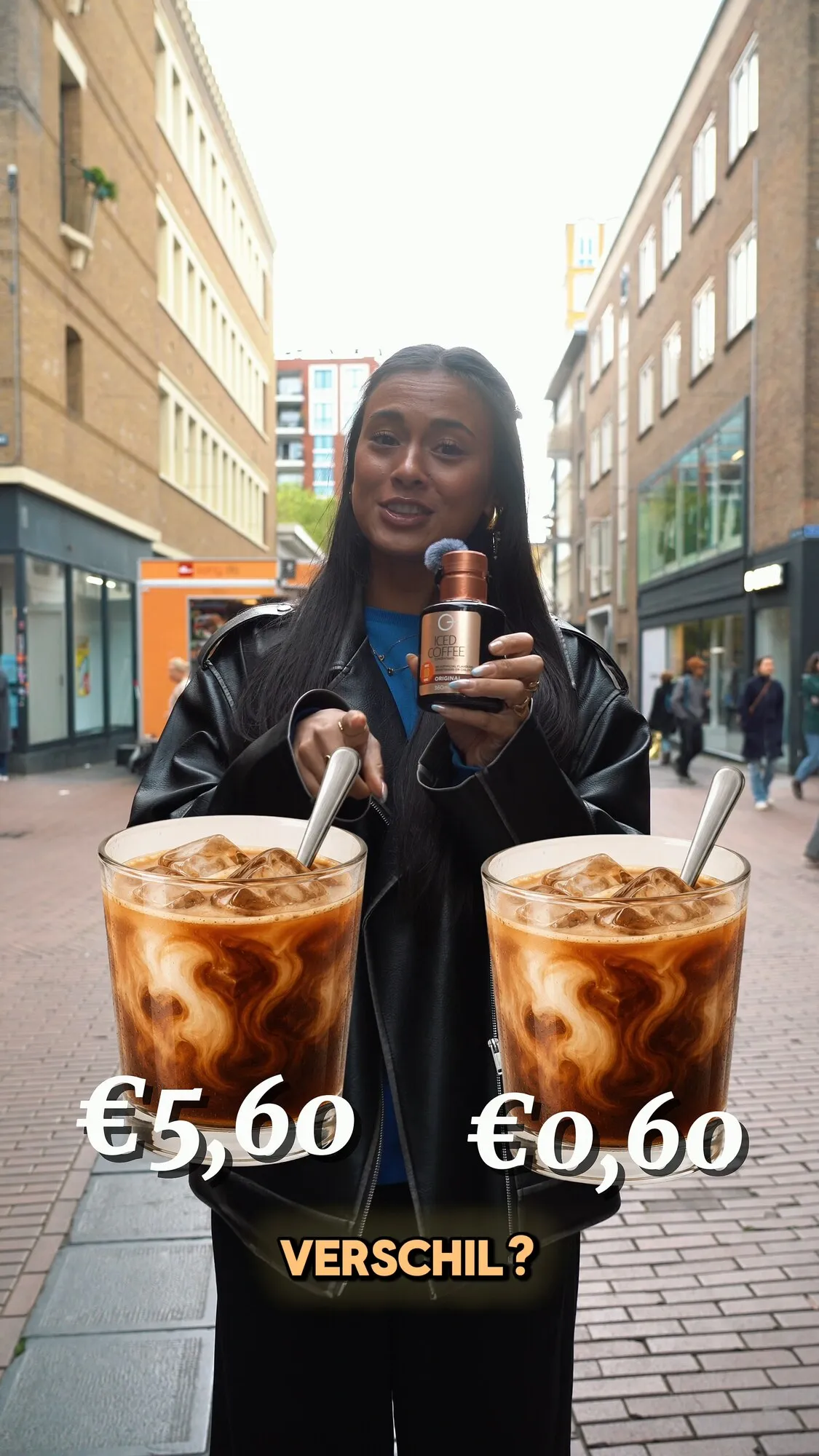 Vrouw houdt twee ijskoffies vast met de prijzen 5,60 euro en 0,60 euro in beeld
